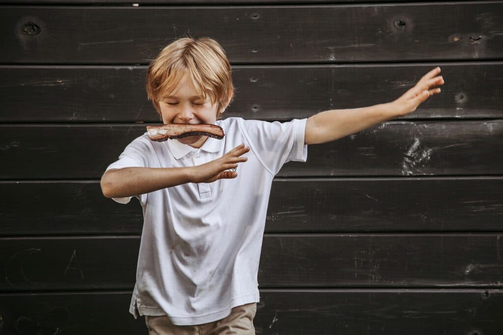 A young guest enjoying a barbecue rib