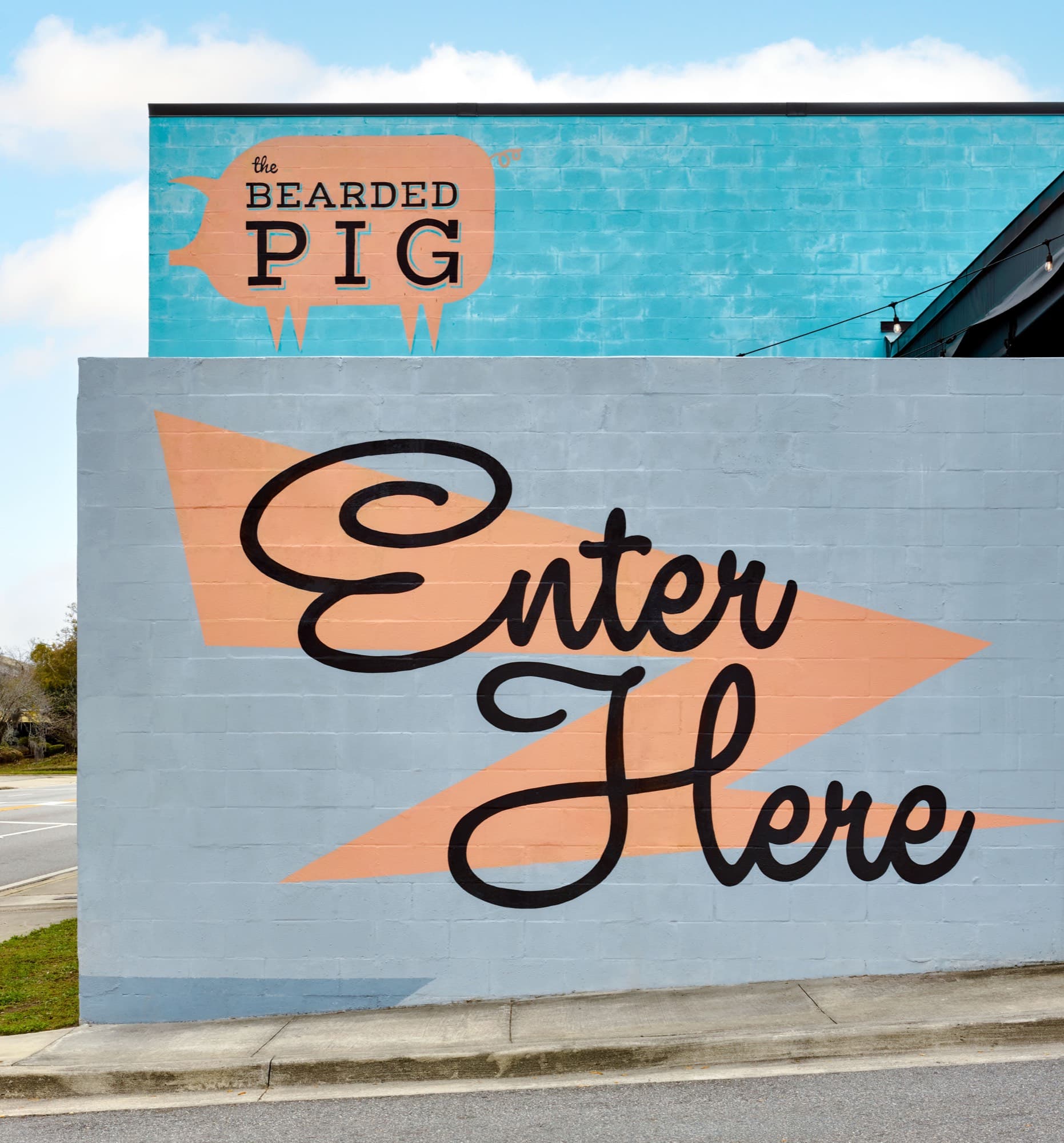 The Bearded Pig's orange Swine mural and Enter Here sign on the Kings Avenue exterior