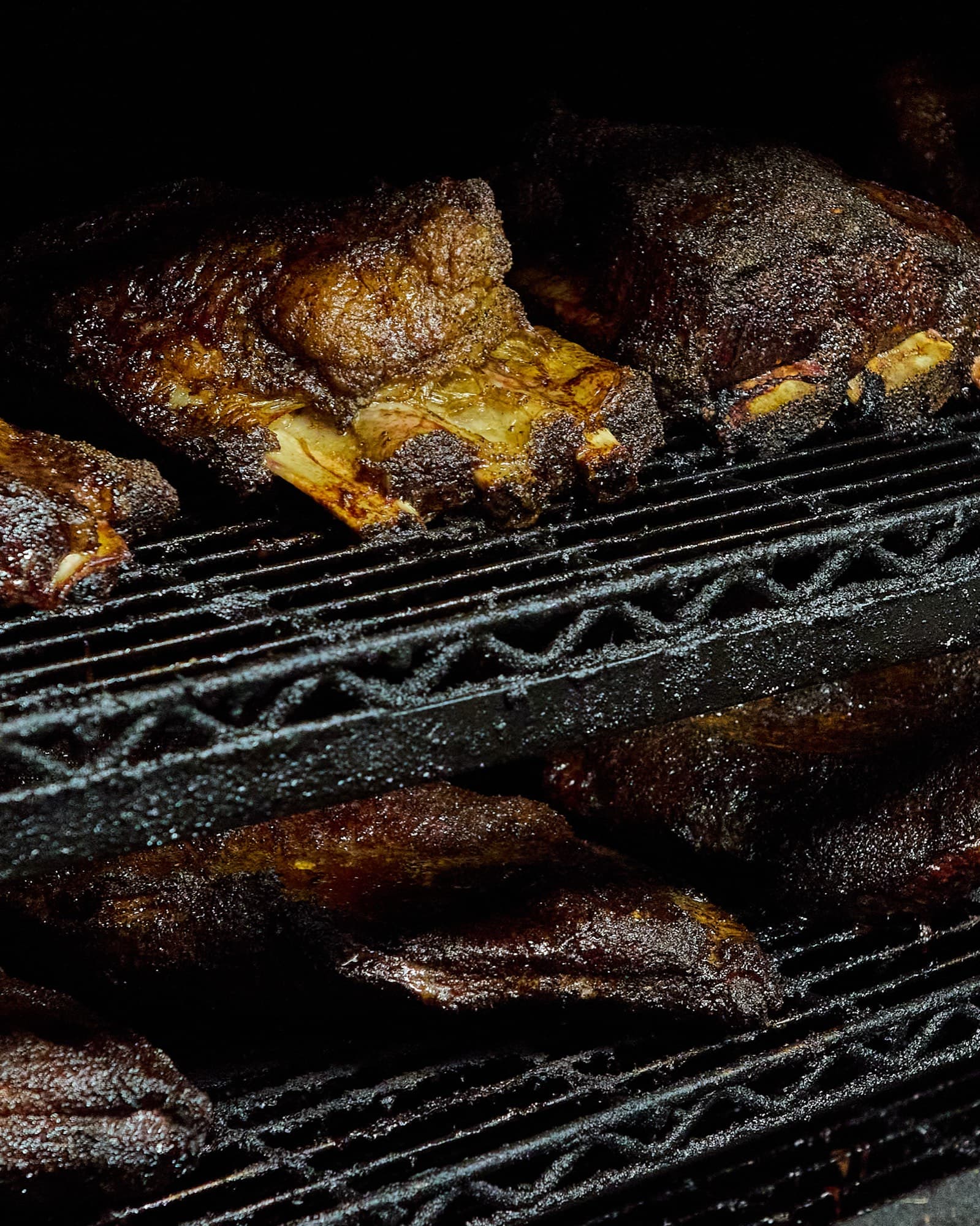 Beef ribs resting on the racks inside The Bearded Pig's smoker
