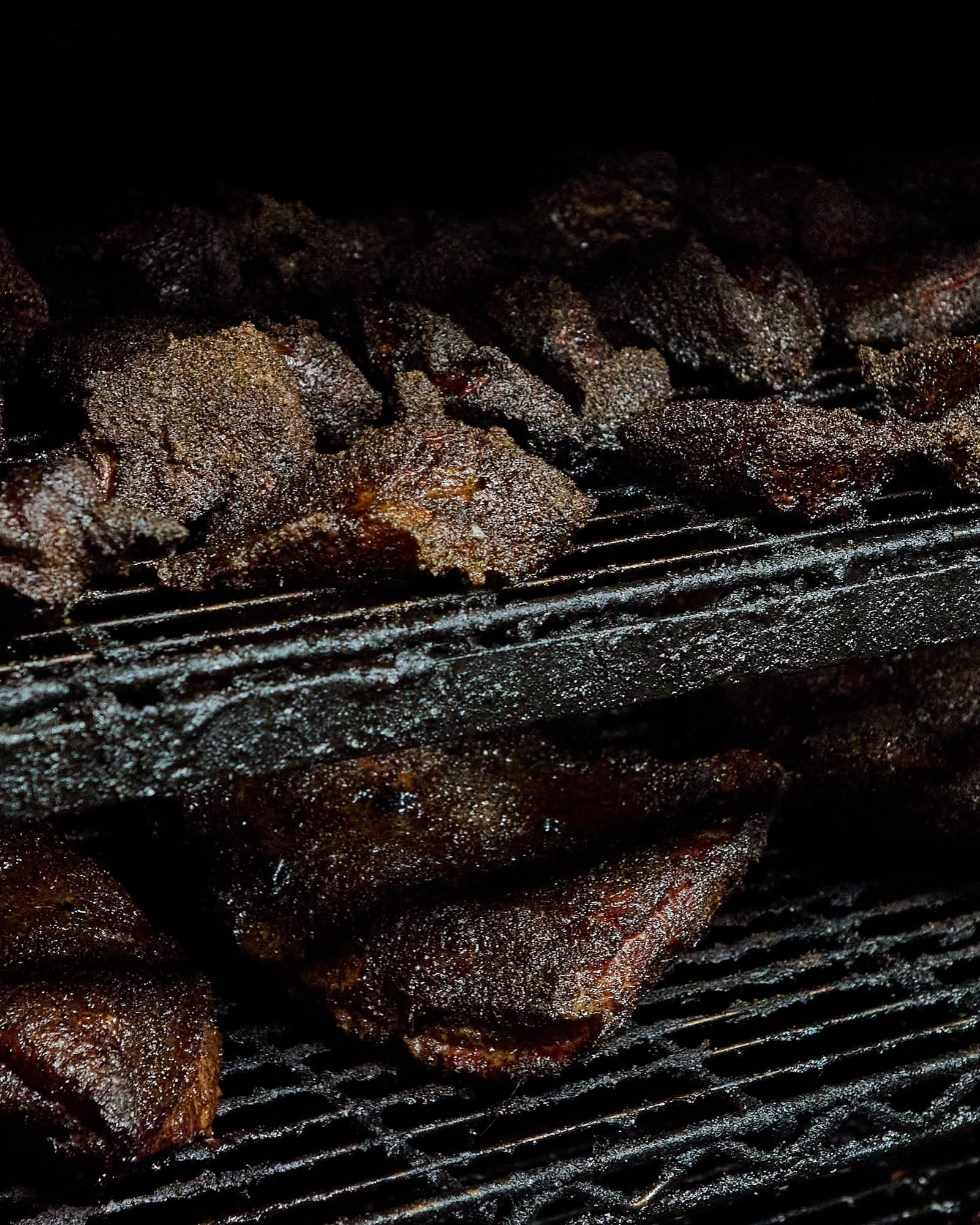 Bark-crusted smoked beef resting on the racks inside The Bearded Pig's smoker